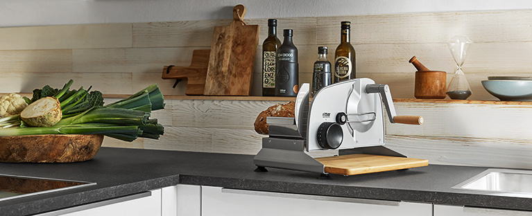 A picture of a manual all-purpose slicer standing in a kitchen.