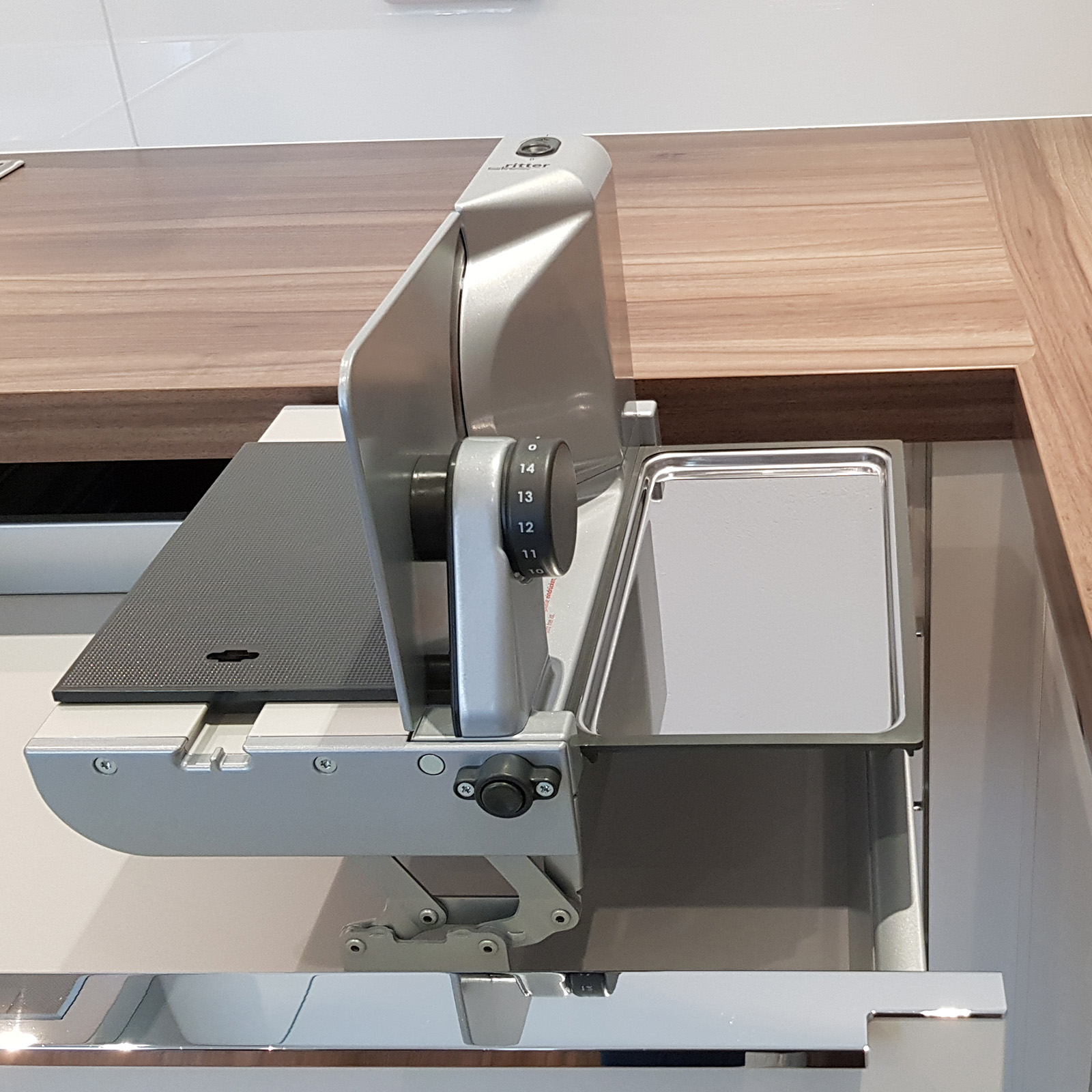 Ein Bild von einem rechtsgeführten Einbau-Allesschneider, der korrekt in eine Schublade eingebaut ist.