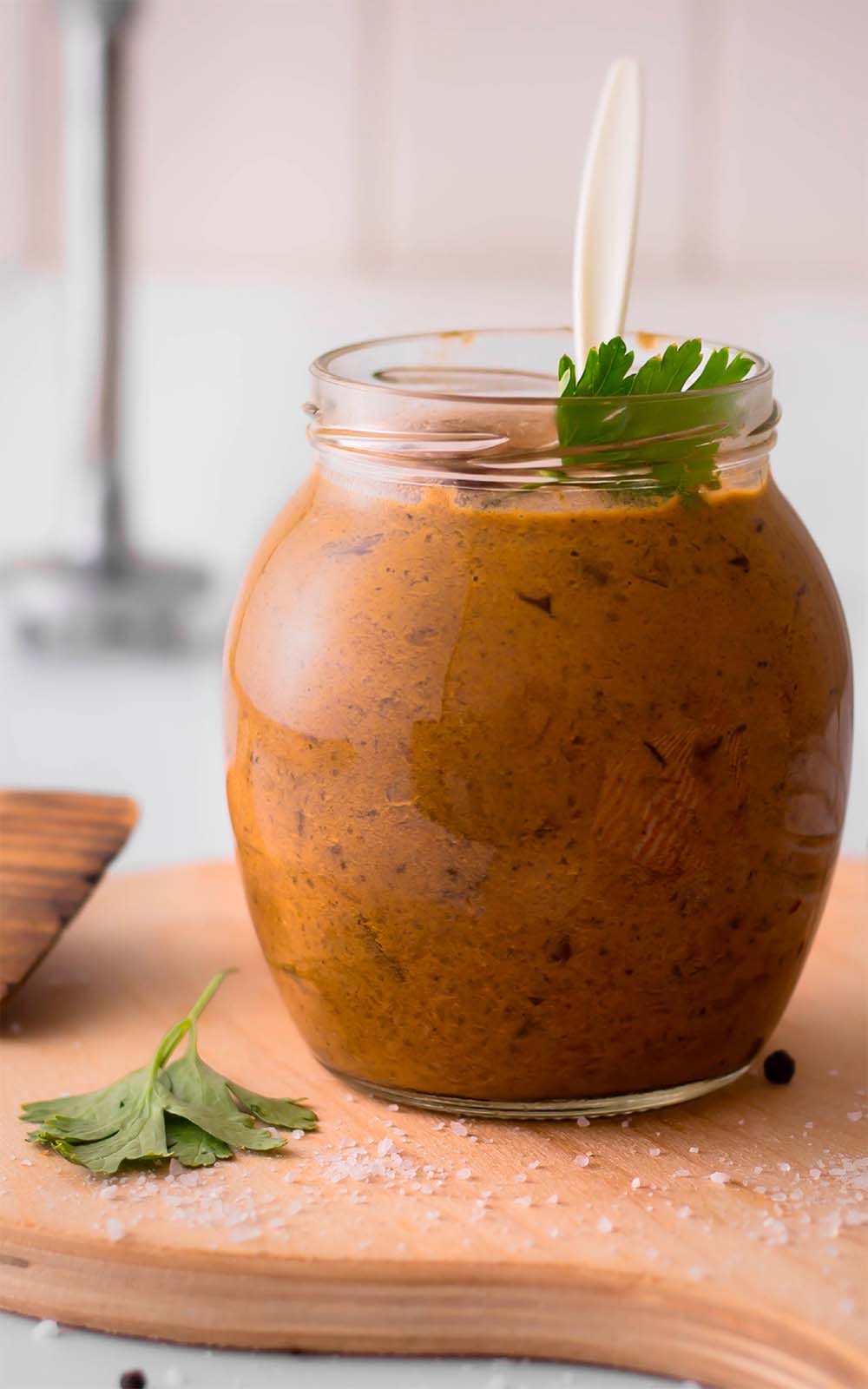Ein Glas gefüllt mit cremiger brauner Jägersauce, garniert mit einem Petersilienblatt. Das Glas steht auf einem Holzbrett, daneben liegt grobes Salz und ein Holzspatel. Ein Glas gefüllt mit cremiger brauner Jägersauce, garniert mit einem Petersilienblatt. Das Glas steht auf einem Holzbrett, daneben liegt grobes Salz und ein Holzspatel.