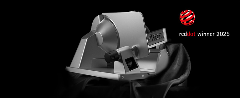 An image of a fine cutter emerging from a black cloth and a reddot winner 2025 award.