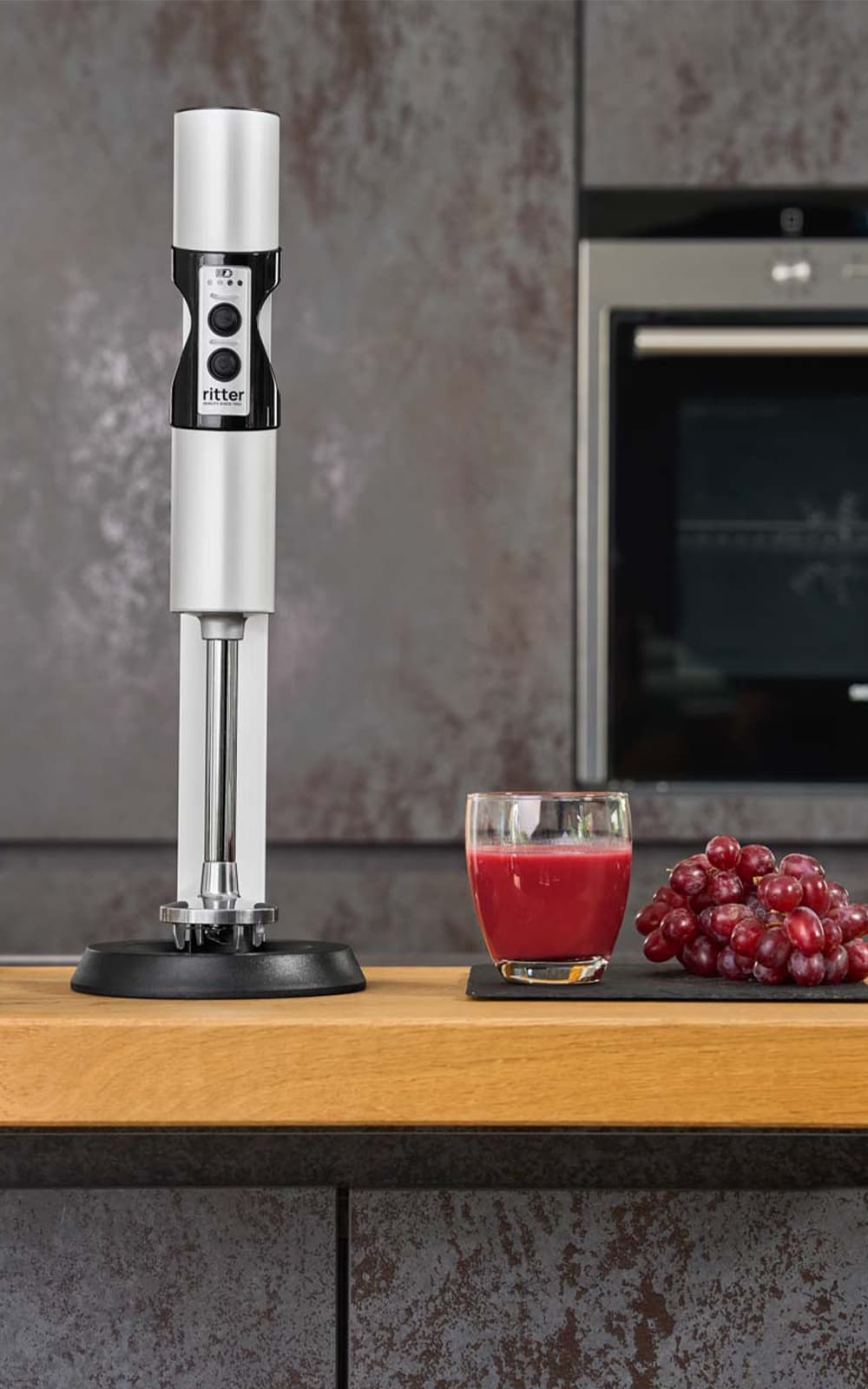 Stabmixer in moderner Küche mit Saft und Weintrauben Stabmixer in moderner Küche mit Saft und Weintrauben