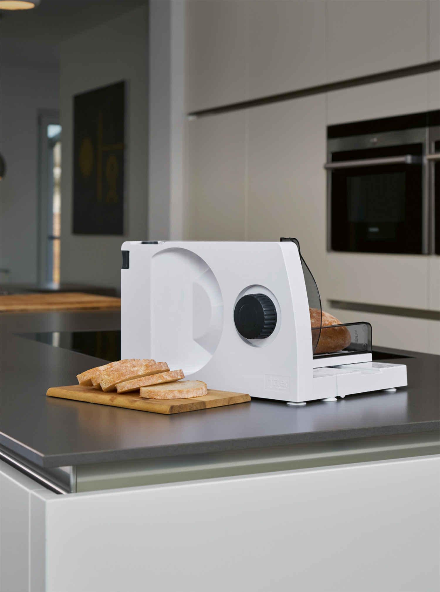 White plastic food slicer in kitchen with sliced bread on wooden board
