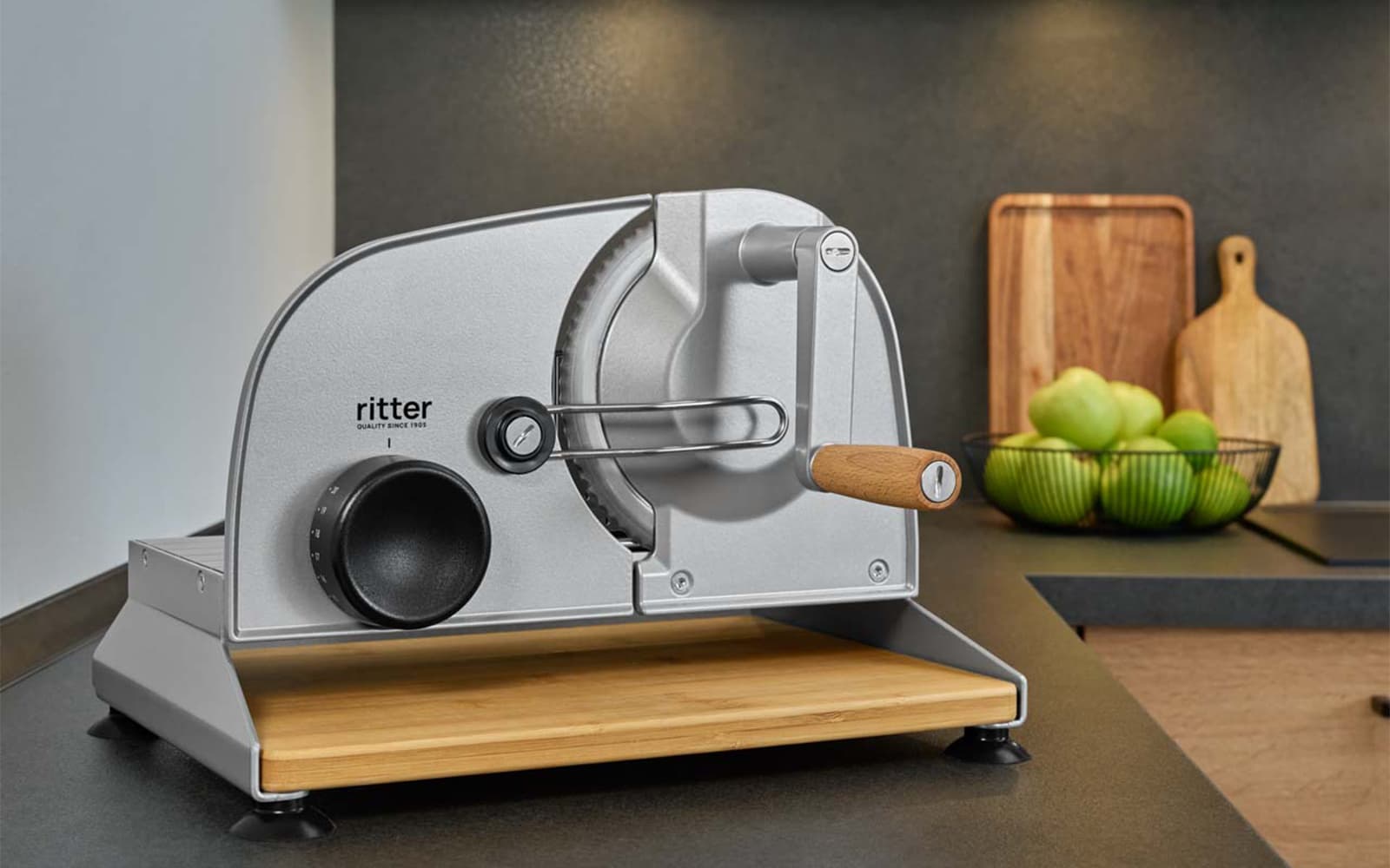 Ein Bild eines manuellen Allesschneiders mit Holzbrett, der auf einer Küchenplattform steht.