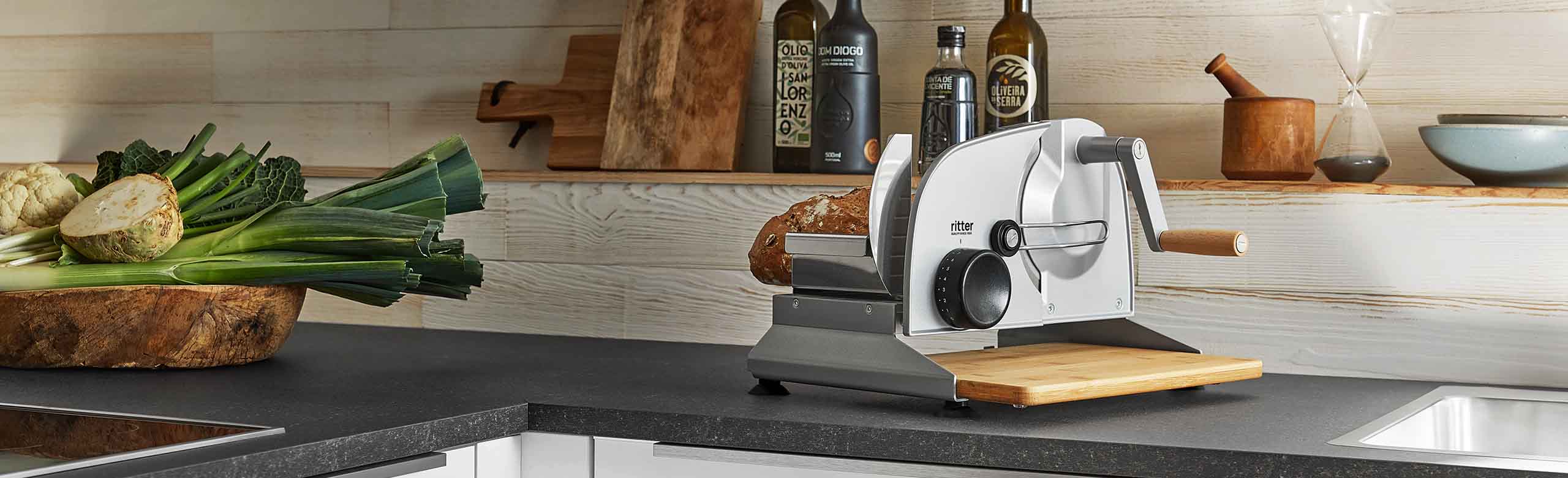 A picture of a manual all-purpose slicer standing in a kitchen.