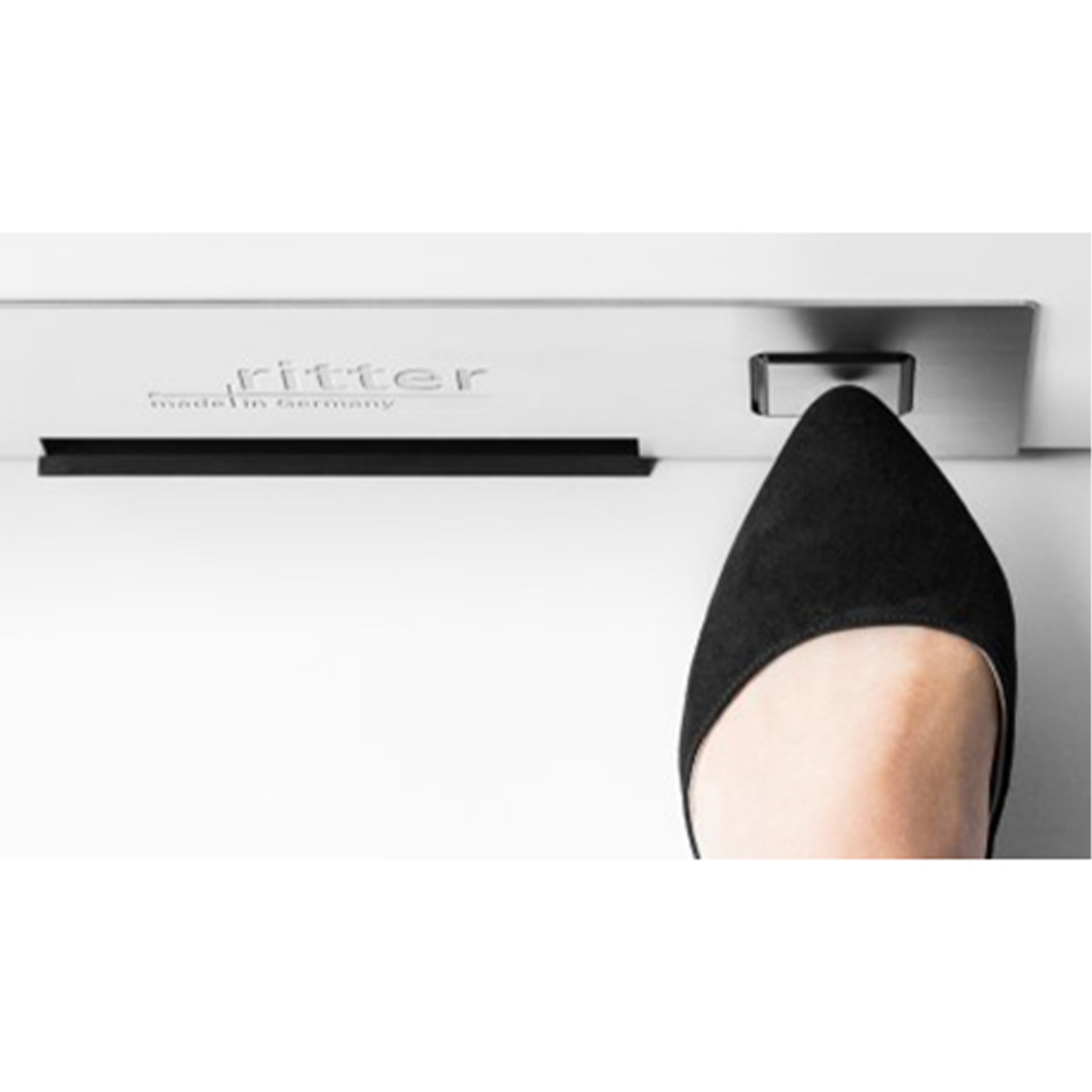 Ein Bild von einem Fuß, der den Anschaltknopf des Einbau-Sockelsaugers drückt.