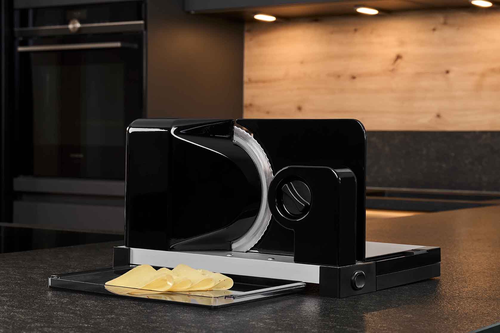 Electric food slicer with sliced cheese, in modern kitchen