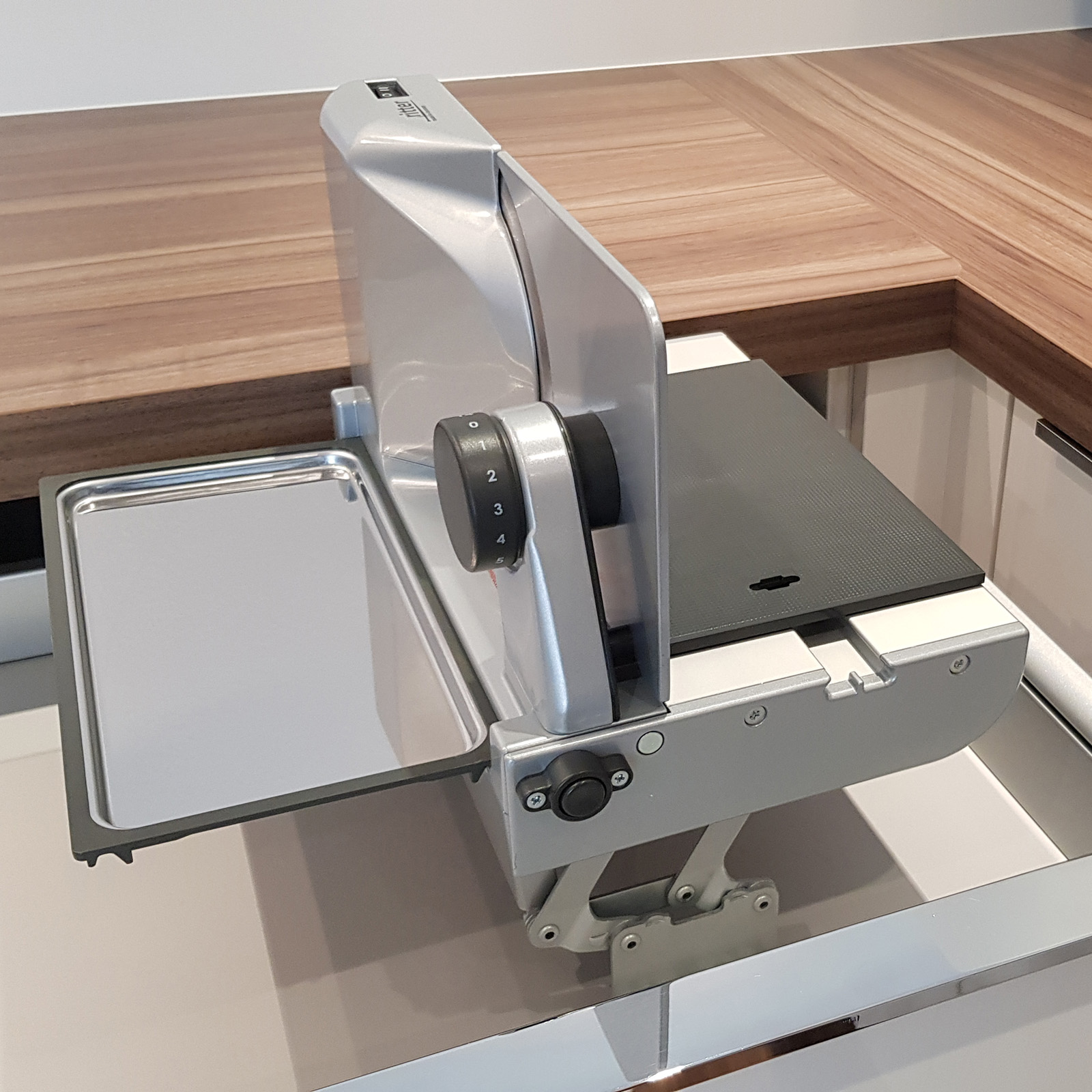 Ein Bild von einem rechtsgeführten Einbau-Allesschneider, der korrekt in eine Schublade eingebaut ist.