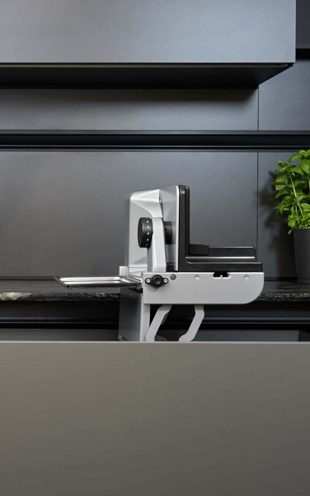 A picture of a built-in all-purpose slicer emerging from a kitchen drawer. A picture of a built-in all-purpose slicer emerging from a kitchen drawer.