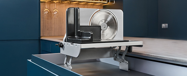 A picture of a built-in all-purpose slicer emerging from a kitchen drawer.