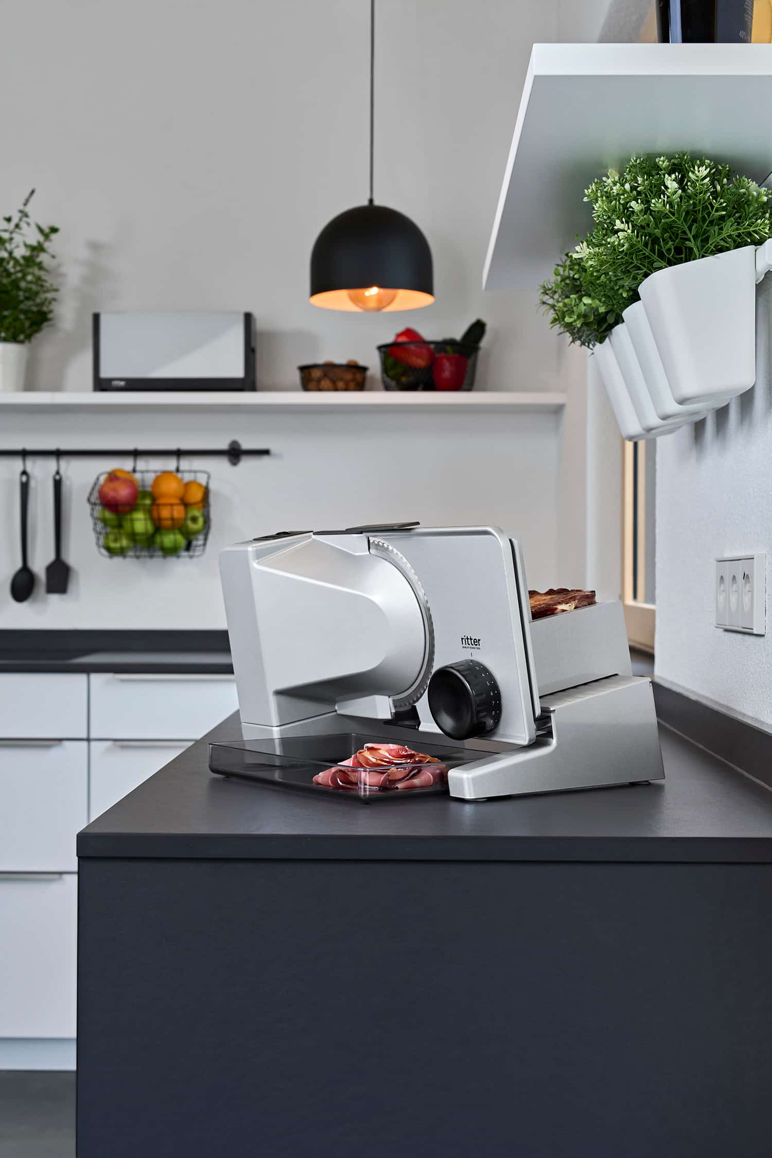 Elektrischer Allesschneider mit geschnittener Salami, in moderner Küche