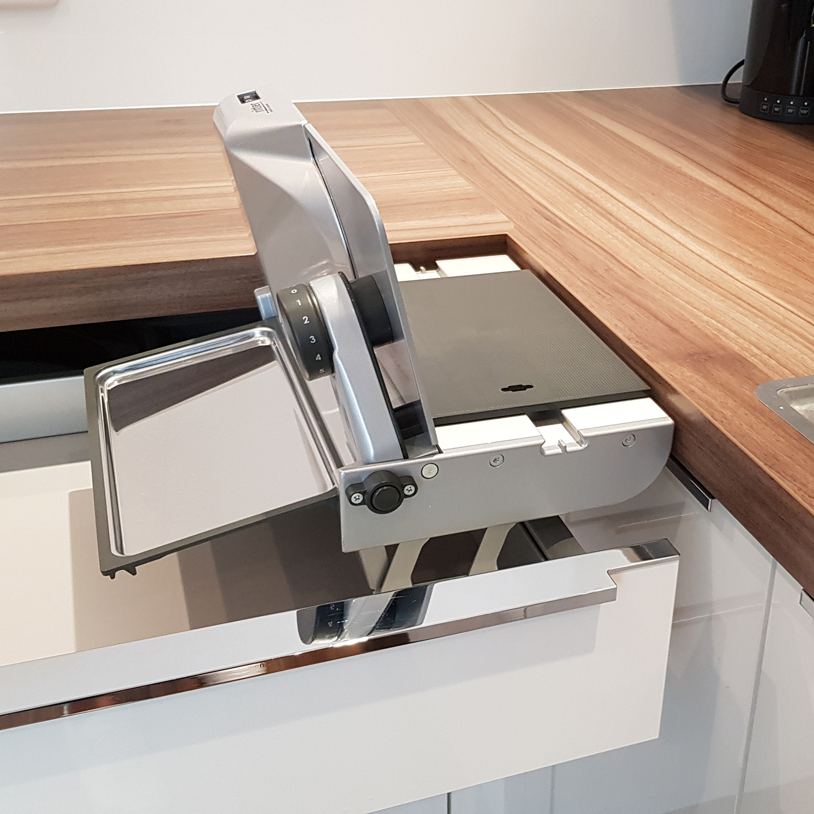 Ein Bild von einem rechtsgeführten Einbau-Allesschneider, der falsch in eine Schublade eingebaut ist.