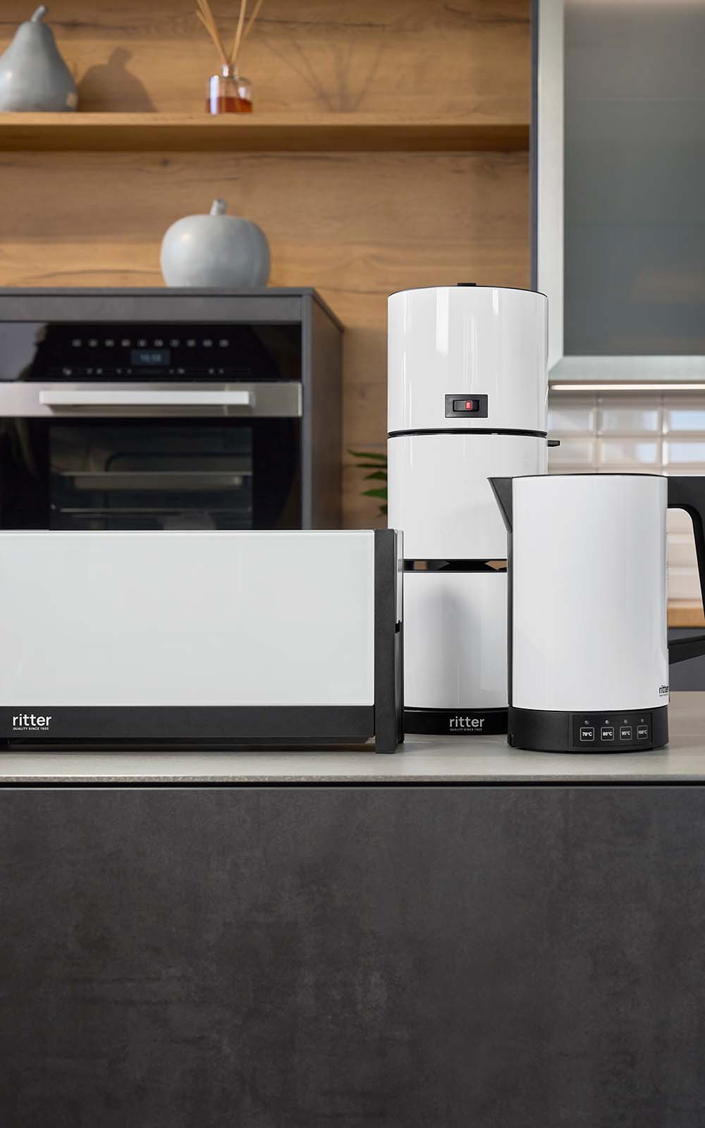 Frühstücksset mit weißem Toaster, weißer Kaffeemaschine und weißem Wasserkocher in schwarzer Küche Frühstücksset mit weißem Toaster, weißer Kaffeemaschine und weißem Wasserkocher in schwarzer Küche