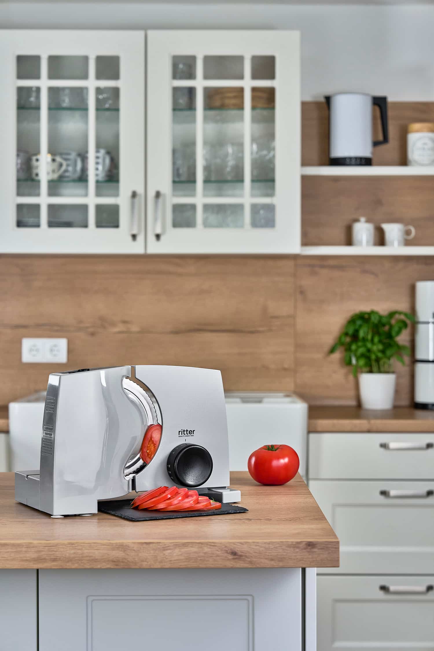 Elektrischer Allesschneider mit geschnittenen Tomaten, in moderner Küche