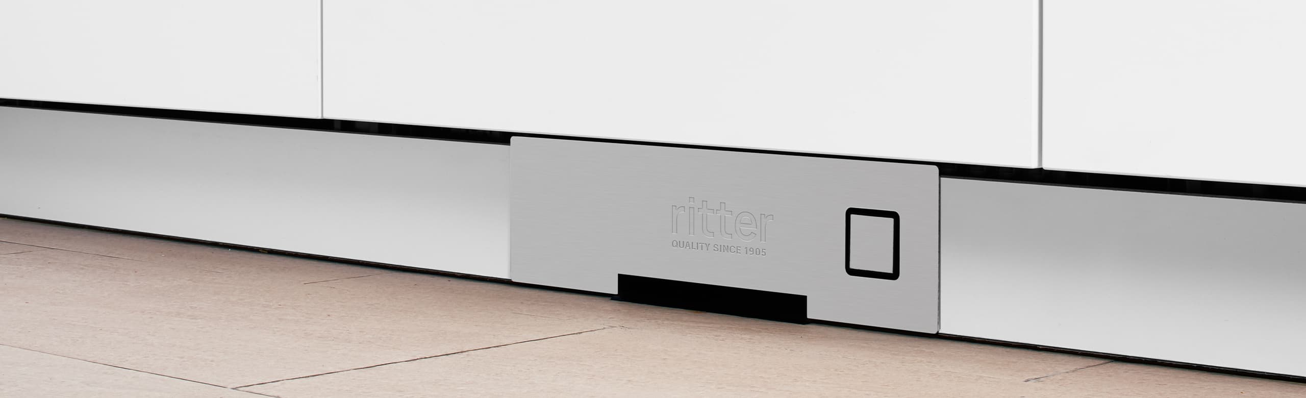 Ein Bild von einem Einbau-Sockelsauger, der in eine Küchenleiste eingebaut ist.