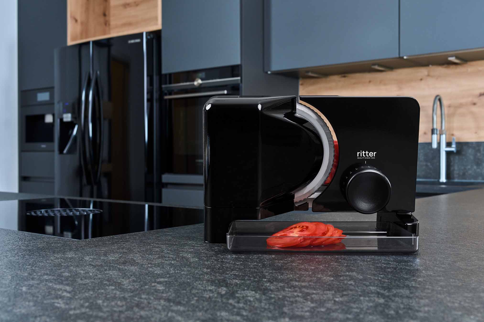 Electric food slicer with sliced tomato, in modern kitchen
